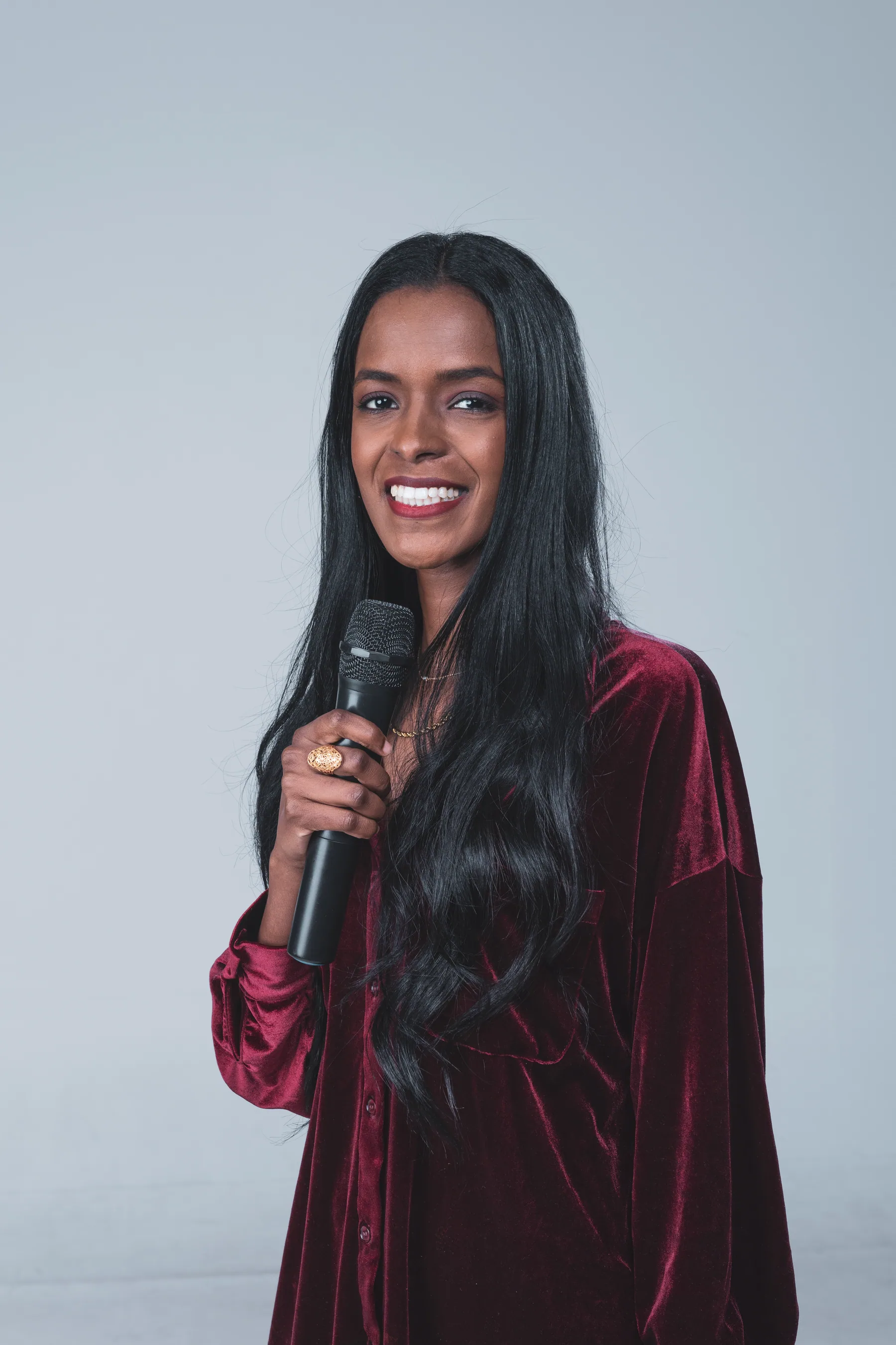 Sahar Ali smiling and holding a microphone